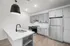 Modern kitchen with sleek grey cabinets, stainless steel appliances, and an elegant pendant light over a spacious white island.