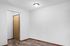 Inviting entryway with wooden door and sleek laminate flooring, offering a warm welcome to a modern apartment.