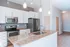 Modern kitchen featuring granite countertops, sleek stainless steel appliances, and elegant pendant lighting.