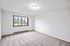 Bright and inviting room with plush carpet, large window offering scenic views, and ample natural light.
