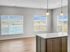 Bright open-concept dining area with large windows overlooking a scenic view, adorned with stylish pendant lights and elegant hardwood floors.