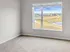 Bright, spacious room with large window overlooking a scenic park and pond, ideal for serene living.