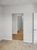 Bright interior view showcasing a room with plush carpet leading to a modern bathroom featuring wooden flooring and elegant finishes.