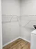 Spacious walk-in closet with modern shelving and sleek wooden floors, perfect for organized storage solutions.