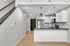 Modern apartment kitchen with sleek black countertops, stainless steel appliances, stylish pendant lighting, and a convenient open layout.
