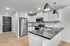 Modern kitchen with sleek appliances, elegant white cabinetry, and stylish pendant lighting showcasing a contemporary design.