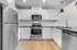 Modern kitchen featuring sleek stainless steel appliances, elegant white cabinetry, and chic pendant lighting.