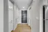 Inviting entry hallway with sleek modern doors and elegant wooden flooring, leading to a comfortable and stylish living space.