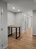Modern hallway with sleek wooden floors and a stylish minimalist table, offering a welcoming atmosphere.