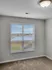 Bright and inviting room with large window offering serene outdoor views, perfect for a cozy retreat.