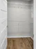 Spacious walk-in closet with elegant wooden flooring and ample shelving for organized storage.