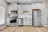 Modern kitchen with sleek stainless steel appliances, elegant white cabinetry, and hardwood floors.