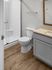 Modern bathroom with elegant wooden flooring, sleek shower enclosure, and contemporary vanity in a sophisticated setting.