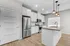 Modern kitchen with stainless steel appliances, elegant white cabinetry, and sophisticated pendant lighting over a spacious island.