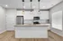 Modern kitchen with sleek white cabinets, stainless steel appliances, and elegant pendant lighting over a spacious island.