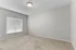 Bright and inviting room with plush carpet and ample natural light through a large window with blinds.