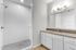 Modern bathroom with elegant white subway tiles, sleek vanity, and bright overhead lighting.