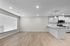 Modern open-concept living space with elegant hardwood flooring, large window, and sleek kitchen cabinetry.