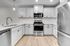 Elegant modern kitchen with sleek white cabinetry, stainless steel appliances, and a chic subway tile backsplash.