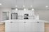 Modern kitchen with sleek white cabinetry, stainless steel appliances, and elegant pendant lighting over a spacious island.