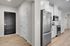Modern kitchen entrance featuring sleek stainless steel appliances, elegant cabinetry, and inviting wood flooring.