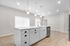 Modern kitchen with a sleek island, bright pendant lighting, and elegant hardwood floors.