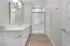 Elegant bathroom featuring a sleek glass shower, spacious vanity with modern fixtures, and warm wood flooring.