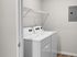 Bright utility room featuring modern washer and dryer with ample shelving space.