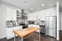 Modern kitchen with sleek stainless steel appliances, white cabinetry, and a stylish wooden island.