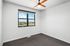 Bright and airy bedroom with a stylish ceiling fan, large window offering scenic views, and fresh carpeting.
