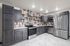 Modern kitchen with sleek stainless steel appliances, elegant dark cabinetry, and stylish tile backsplash.