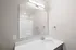 Modern bathroom with sleek vanity, large mirror, and ambient lighting.