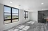 Modern apartment with bright natural light, large windows, and sleek open-plan kitchen.