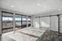 Bright and airy room with large windows offering panoramic views, modern sliding doors, and sleek tile flooring.