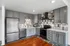 Modern kitchen with sleek grey cabinetry, stainless steel appliances, and elegant tiled backsplash.