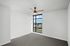 Bright, modern room with large window, offering scenic views and ample natural light, featuring a stylish ceiling fan and fresh carpet flooring.