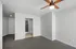 Modern bedroom with cozy carpet flooring, sleek ceiling fan, and spacious walk-in closet.