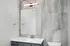 Modern bathroom with a sleek vanity, illuminated mirror, and elegant tile wall.