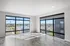 Bright, spacious room with floor-to-ceiling windows offering a panoramic city view; perfect for modern living.