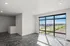 Bright and modern living space with expansive floor-to-ceiling windows offering a stunning cityscape view.