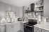 Modern kitchen with sleek gray cabinets, elegant tiled backsplash, and stainless steel appliances.