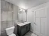 Modern bathroom featuring sleek gray tiles, elegant vanity with integrated sink, and contemporary lighting.