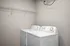 Modern laundry room with sleek washer and dryer beneath a spacious storage shelf.