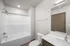 Modern bathroom with a sleek white bathtub, elegant fixtures, and a spacious mirrored vanity.