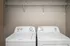 Modern laundry room with sleek washer and dryer set beneath spacious wire shelving.