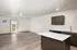 Bright and modern open-concept living space with sleek kitchen cabinetry, spacious island, and natural light from the patio door.