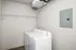 Modern laundry room featuring a sleek washer and dryer set with a spacious storage shelf above.