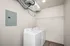 Bright and modern laundry room with energy-efficient washer, dryer, and ample shelving space.