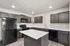 Modern kitchen with sleek dark cabinets, stainless steel appliances, and a spacious white island centerpiece.