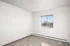 Bright, empty room with neutral walls, carpet flooring, and a large window offering scenic views.
